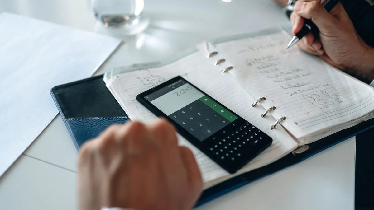 Persona haciendo cálculos para un presupuesto en un cuaderno