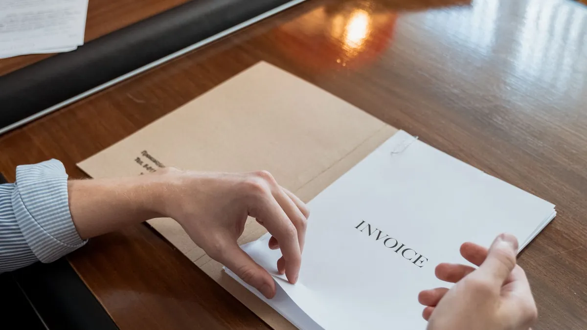 Autónomo revisando una factura impresa en su escritorio