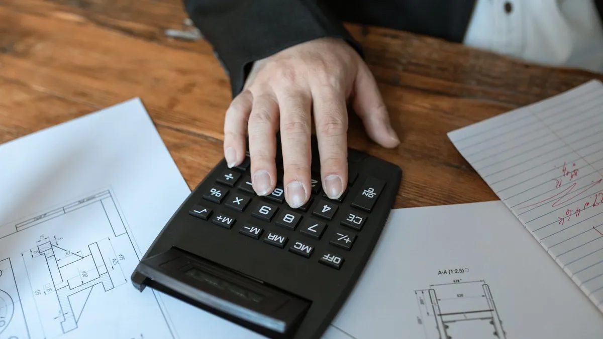 Persona usando una calculadora para preparar un presupuesto