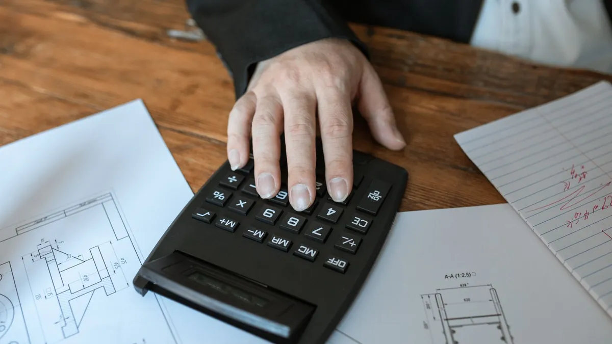 Persona usando una calculadora para preparar un presupuesto
