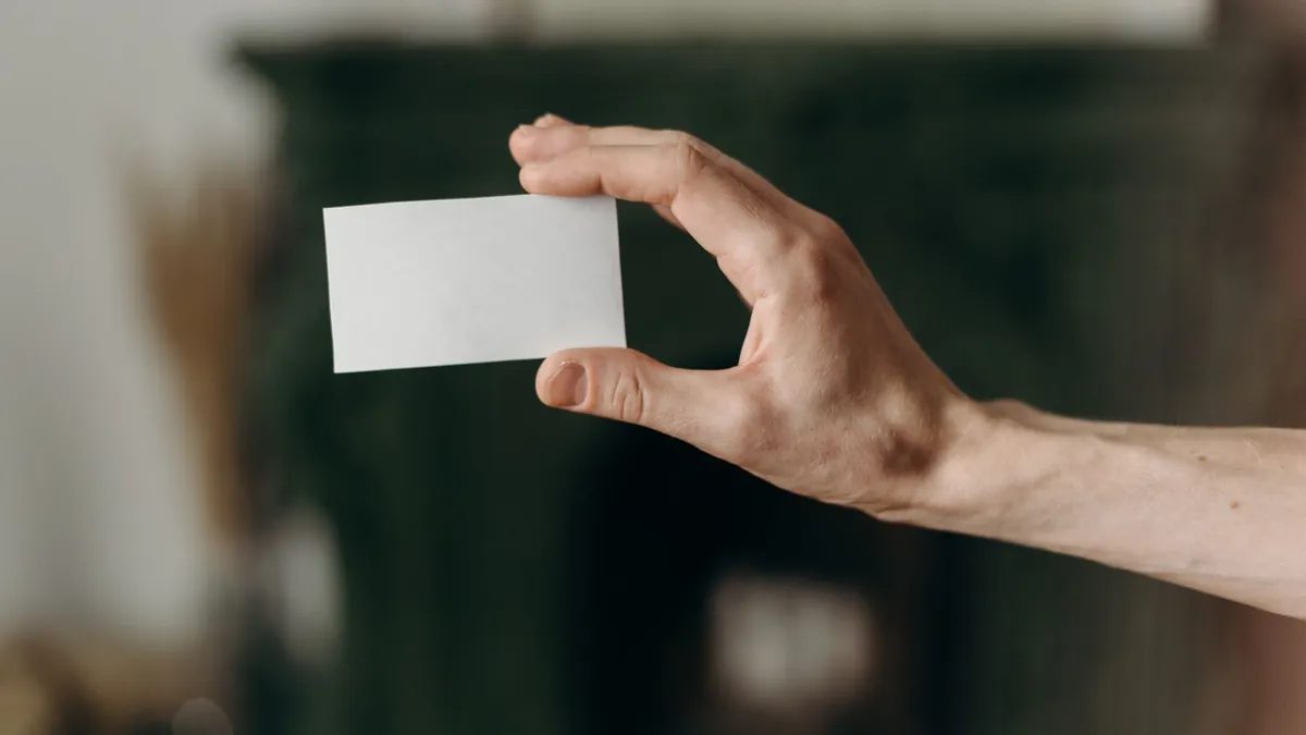 Mano sosteniendo una tarjeta de visita en blanco