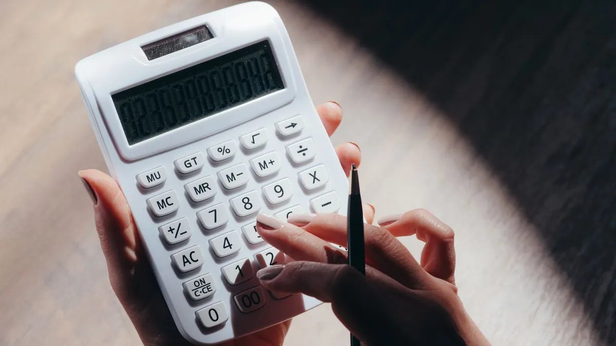 Persona usando una calculadora para calcular la retención de IRPF